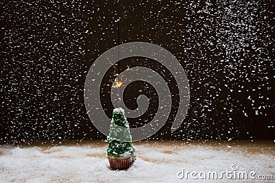 Christmas tree with sparkler on a background of snow. Stock Photo