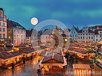Christmas tree in Tallinn old town hall square without snow ,moon on blue sky ,best in Europe Christmas market place kiosk ,holid Stock Photo