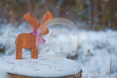 Christmas-tree toy deer with a ribbon on the snow. With a copy-space. Stock Photo