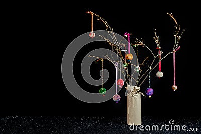 Christmas twig tree table decoration. Colourful baubles and black background. Stock Photo