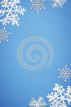 Christmas vertical composition with border of white decorative snowflakes on blue background. Flat lay, top view, copy Stock Photo