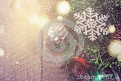 Christmas Vintage card. Coniferous branches and snowflakes on wooden background. Bokeh lights Stock Photo