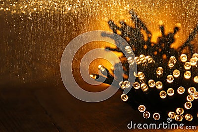 Christmas warm gold garland lights on wooden rustic background. filtered image Stock Photo