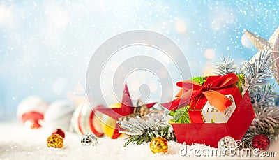 Christmas winter background with gift box, Christmas baubles and fir tree branches on snow Stock Photo