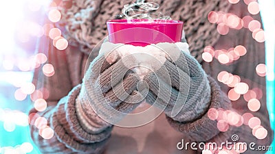 Christmas winter background - Young pretty woman with gloves and scarf stands outdoor and holds a pink hot steaming teacup / cup Stock Photo