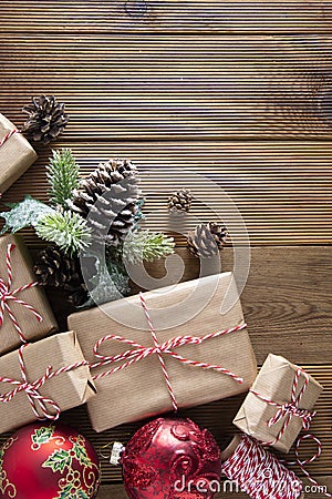 Christmas and winter holidays background. Cchristmas gift box with pine cones, fir brances, on brown wood table with copy space. Stock Photo