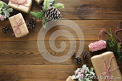 Christmas and winter holidays background. Cchristmas gift box with pine cones, fir brances, on brown wood table with copy space. Stock Photo