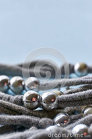 Knitted threads with silver coloured beads against blue Stock Photo