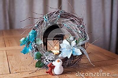 Christmas wreath of branches on the fur skin with the company of a snowman and a dog with a candle in the background Stock Photo