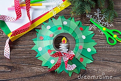 Christmas wreath with a candle on a written wooden table. Made by own hands. Stock Photo
