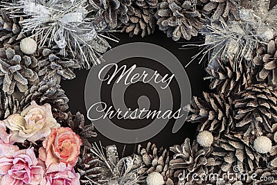 Christmas wreath of cones close-up. In the center there is an inscription merry Christmas. Stock Photo