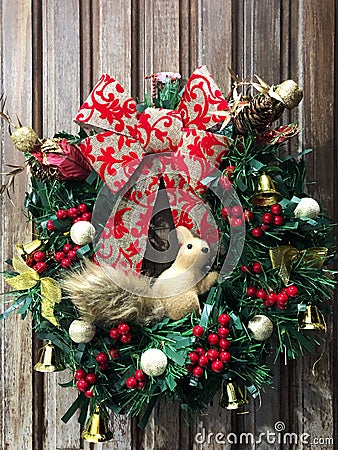 Christmas wreath decorated with bows, bells, berries and a squirrel Stock Photo