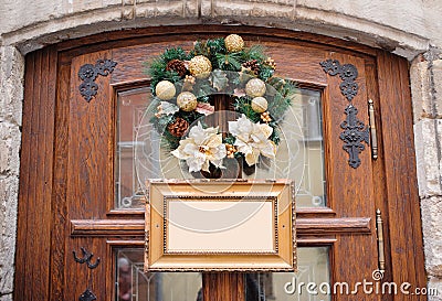 Christmas wreath decorated with gold balls on wooden door and frame with place for your text Stock Photo