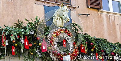 Christmas wreath and decorations on facade with sculpture of horse. Stock Photo