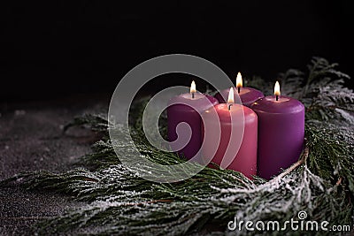 Christmas wreath with four burning purple advent candles Stock Photo