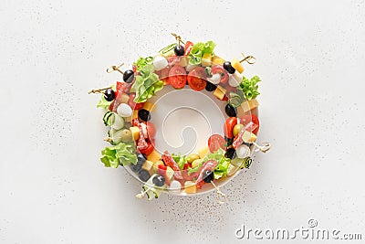 Christmas wreath of holiday snacks, canapes, tomatoes, olive, vegetables, cheese Stock Photo