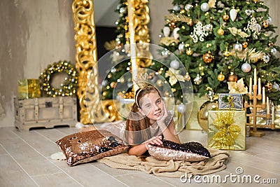 Christmas xmas casual gold studio decorations with cute girl and huge mirror with golden frame plenty presents and big green pine Stock Photo