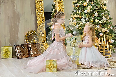 Christmas xmas casual gold studio decorations with cute girl and huge mirror with golden frame plenty presents and big green pine Stock Photo