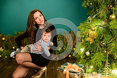 Christmas with your beloved mom. Merry Christmas and happy holidays Cute son gives a present to his beloved mother. New interior Stock Photo