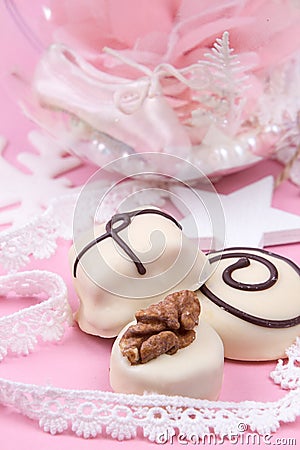 Christmass New Year decorations. Greeting card. White chocolate candy, Christmass ball with pointe shoe. Tender pink color Stock Photo