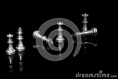Silver chess kings and queens on black reflective background Stock Photo