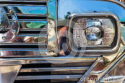 Chrome radiator grille and headlight of a filipino Jeepney in the Philippines. A refurbished bus for public transportation. Stock Photo