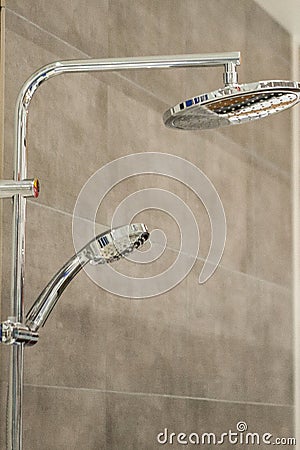 Chrome showerhead and rail on grey tiles Stock Photo