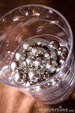 Chrome spheres in clear glass next to the window. Stock Photo