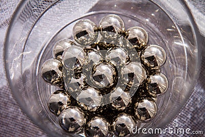 Chrome spheres in clear glass next to the window. Stock Photo