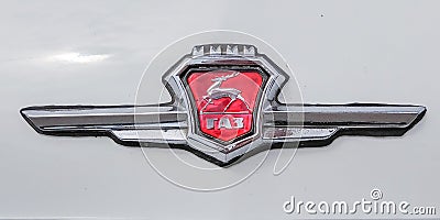 Chromed emblem of blue retro car Volga with deer and inscription GAZ Editorial Stock Photo