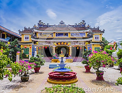 Chua Phap Bao Pagoda through a courtyard garden with flowers and bonsai trees, Hoi An, Vietnam Stock Photo