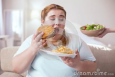 Chubby young woman thinking about her unhealthy eating habits Stock Photo