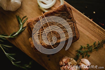 Chunk of salted smoked lard in gauze with a rope.Traditional Russian and Ukrainian meal.Healthy food with spices, herbs Stock Photo