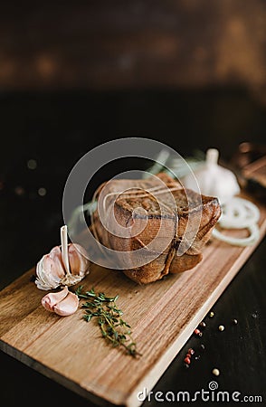 Chunk of salted smoked lard in gauze with a rope.Traditional Russian and Ukrainian meal.Healthy food with spices, herbs Stock Photo