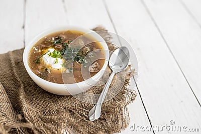 Chunky Italian wedding soup on a light wood background table Stock Photo