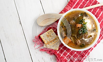 Chunky Italian wedding soup on a light wood background table Stock Photo
