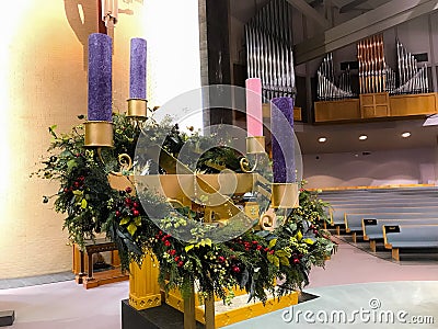 Church Advent Wreath with violet purple and rose candle berries and gold stand Stock Photo