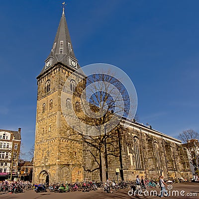Church of Enschede, the Netherlands with many people and bicycles around Editorial Stock Photo