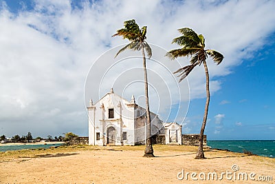 Church and fortress of San Antonio on Mozambique island, with two palm trees on sand. Indian ocean coast, Nampula province. Stock Photo