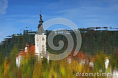 The Church of Mary the Queen mirrored in the water of Lake Bled in autumn. Stock Photo