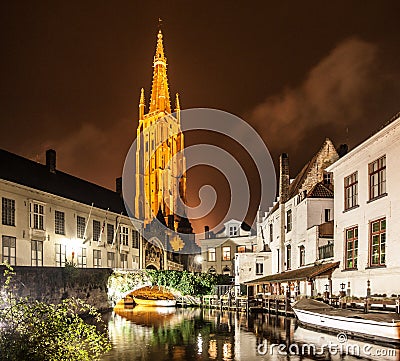 Church of Our Lady and bridge over water canal by night, Bruges, Belgium Stock Photo