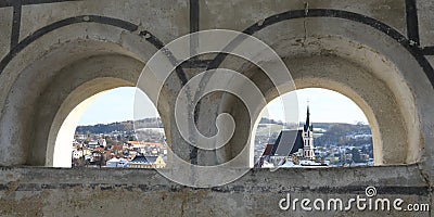 Church and roofs thru windows in wall in Cesky Krumlov Stock Photo