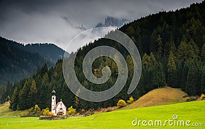 The church of Saint John, Ranui, Chiesetta di san giovanni in Ranui Runes South Tyrol Italy, surrounded by green meadow, forest Stock Photo