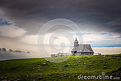 Church in the Slovenia big plateau pasture Velika Planina. Chapel on the hill, religion symbol.Dramatic mystic clouds and colors Stock Photo