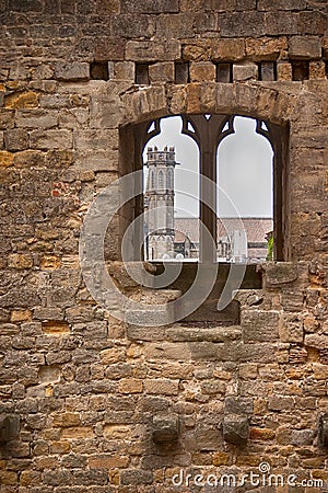 Church spire through a medieval wall Stock Photo