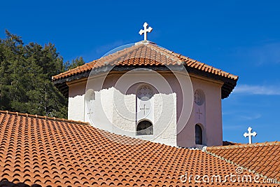 Church stone dome with a cross and a tiled roof close up Stock Photo