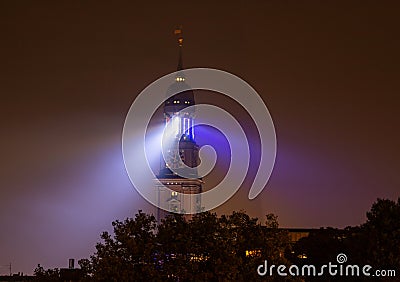 The church tower of Hamburg's Michel glows blue at night, like a lighthouse Stock Photo