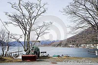 Chuzenji lake with leafless trees and used wheel loader Editorial Stock Photo