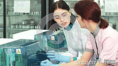 Cientistas dos cuidados médicos que discutem analisando máquinas no laboratório filme Cientistas dos cuidados médicos que discutem analisando máquinas no laboratório filme