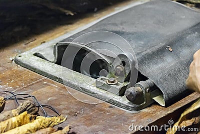 A cigar rolling machine Inside a cigar factory. Traditional manufacture of cigars at the tobacco factory. Making a cigar fromA cig Stock Photo